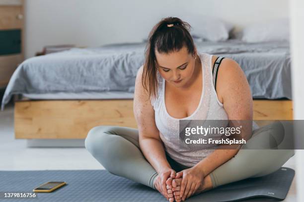 beautiful plus size woman doing yoga in her bedroom in the morning - obesity stock pictures, royalty-free photos & images