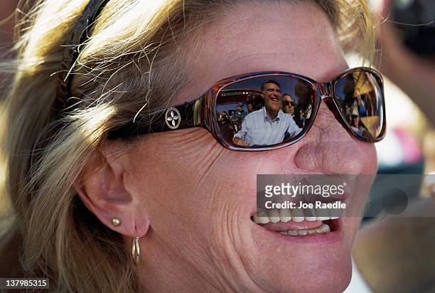Republican presidential candidate and former Massachusetts Gov. Mitt Romney is reflected in the sunglasses of a supporter as he greets people during...