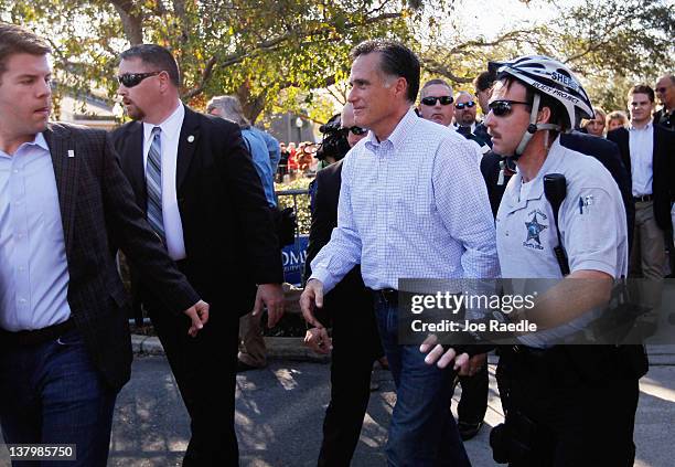 Republican presidential candidate and former Massachusetts Gov. Mitt Romney walks to his bus after a rally with supporters at Pioneer Park on January...