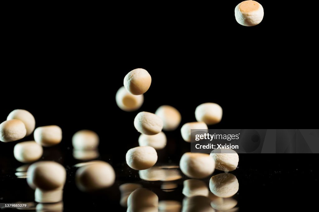 Small ball cookie flying in mid air in black background