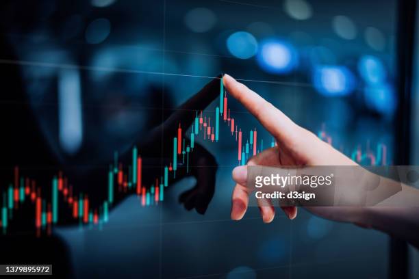 close up of female hand touching stock market analysis digital display screen, analyzing investment and financial trading data in candlestick chart on a touch screen interface. business and finance. investment on nft and cryptocurrency concept - geldanlage stock-fotos und bilder