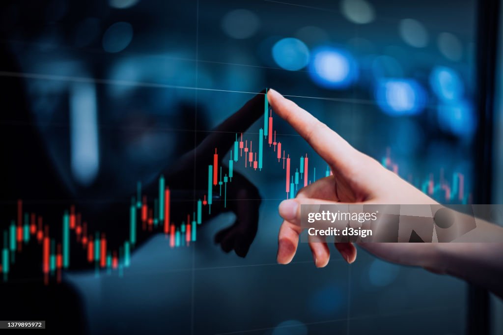 Close up of female hand touching stock market analysis digital display screen, analyzing investment and financial trading data in candlestick chart on a touch screen interface. Business and finance. Investment on NFT and cryptocurrency concept
