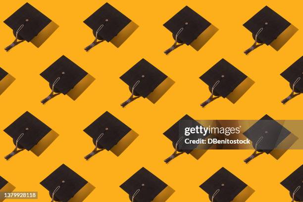 pattern of black graduation caps with gray tassel with hard shadow on yellow background. graduation, achievement, goal, degree, master, bachelor, university, college and success concept. - graduate tassel stock pictures, royalty-free photos & images