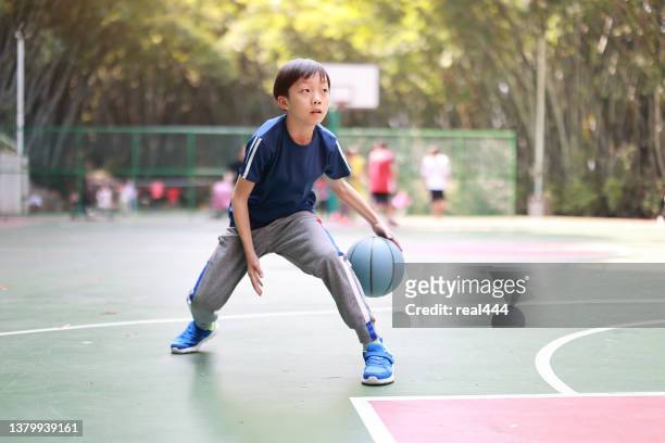 young boy playing basketbal - basketball action stock pictures, royalty-free photos & images