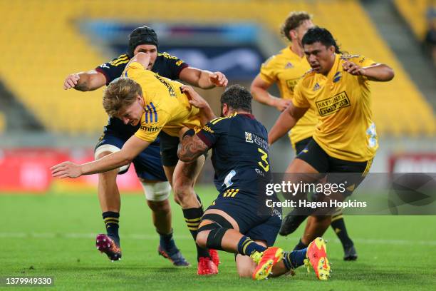 Jordie Barrett of the Hurricanes is tackled during the round three Super Rugby Pacific match between the Hurricanes and the Highlanders at Sky...