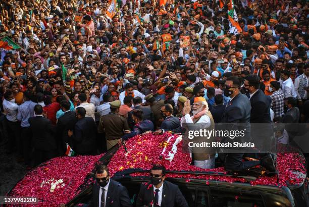 Varanasi, INDIA India's Prime Minister Narendra Modi greets crowds of supporters during a roadshow in support of state elections on March 04, 2022 in...