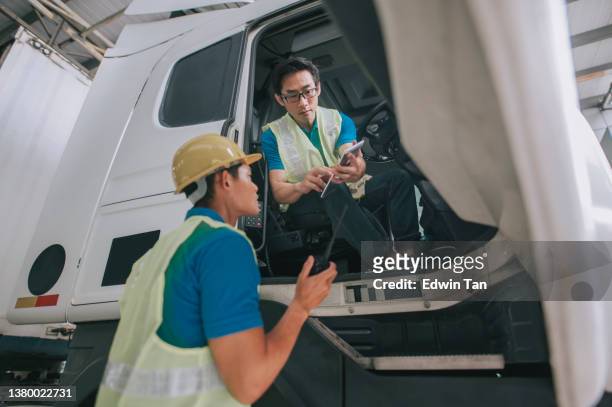 asiatisch-chinesische sattelschlepperfahrer kommunizieren mit fabriklagerarbeiter auf der lieferladeliste - driver's seat stock-fotos und bilder