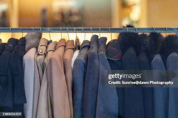 coats on display racks - coat hanging stock pictures, royalty-free photos & images