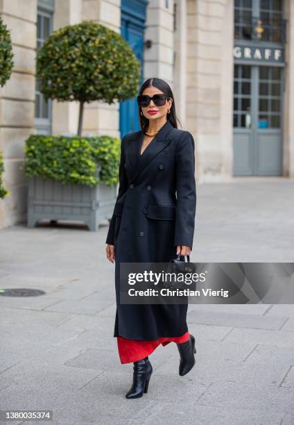 Victoria Barbara is seen wearing black tailored double breasted coat, black Hermes bag, red pants, golden necklace, ankle boots, sunglasses during...