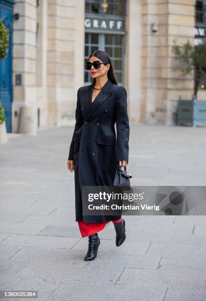 Victoria Barbara is seen wearing black tailored double breasted coat, black Hermes bag, red pants, golden necklace, ankle boots, sunglasses during...