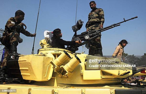 Civilian visitor is seen on top of a T-72 tank during an Indian Army weaponry exhibition in Kolkata on January 31, 2012. The event showcased the...