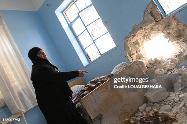 Sister Stefanie, the head of the Sednaya Monastery, shows journalists damage caused to the convent during a recent shelling on January 31, 2012....