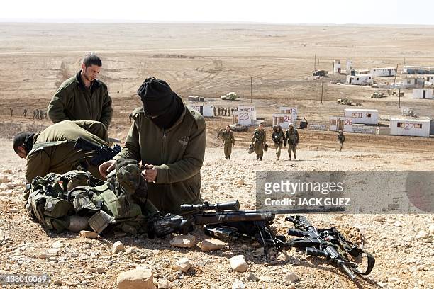 Israeli army snipers pack their gear after an army exercise at the Shizafon army base, in the Negev Desert north of the southern city of Eilat, on...
