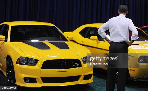 President Barack Obama looks at a Dodge Charger during a visit to the DC Auto Show at the Convention Center January 31, 2012 in Washington, DC. Obama...