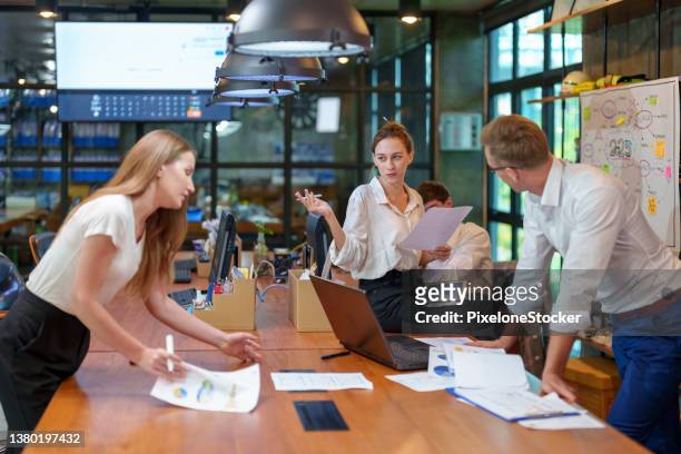 coworkers working on project in modern office. - creative director stock pictures, royalty-free photos & images