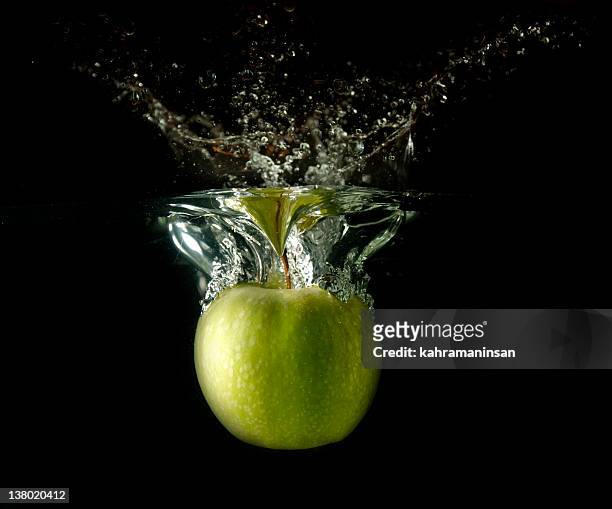 spritzendes wasser apple - apple water splashing stock-fotos und bilder