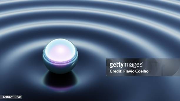 iridescent sphere touching a liquid surface creating ripples - bearings metal stock pictures, royalty-free photos & images