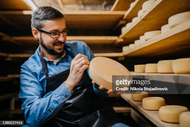 o fabricante de queijo marca o queijo - leiteiro - fotografias e filmes do acervo