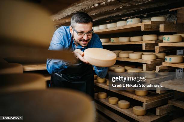 cheese maker in the cellar - cheese maker stock pictures, royalty-free photos & images