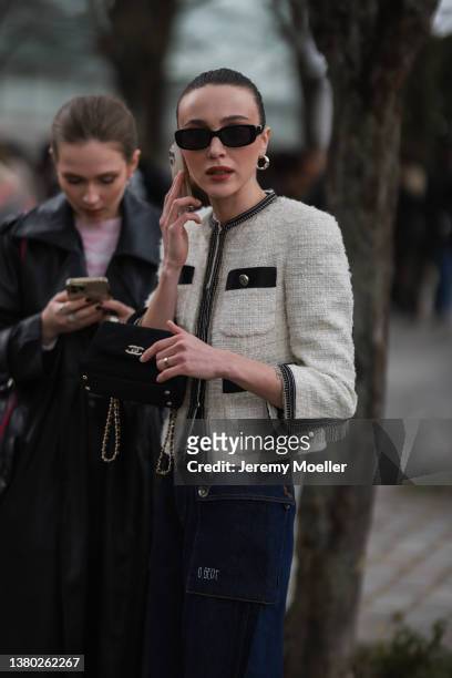 Mary Leest seen wearing a Chanel jacket, blue jeans, black Chanel bag and black sunglasses on March 03, 2022 in Paris, France.