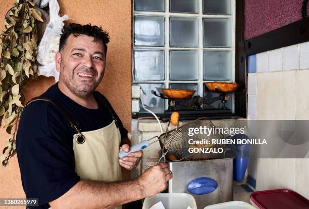 caucasian cook frying croquettes. food and drink concept. - kroket stockfoto's en -beelden