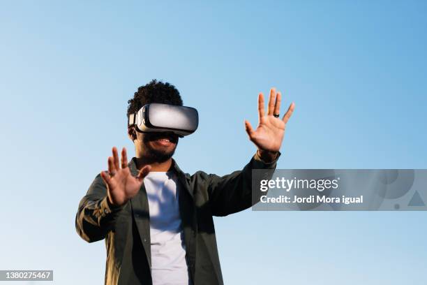 man enjoying experience virtual reality with vr headset device outdoors. - virtual bildbanksfoton och bilder