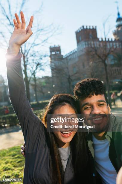 two happy friends smiling and enjoying together while taking a selfie outdoors at the college campus. - selfie male stock pictures, royalty-free photos & images