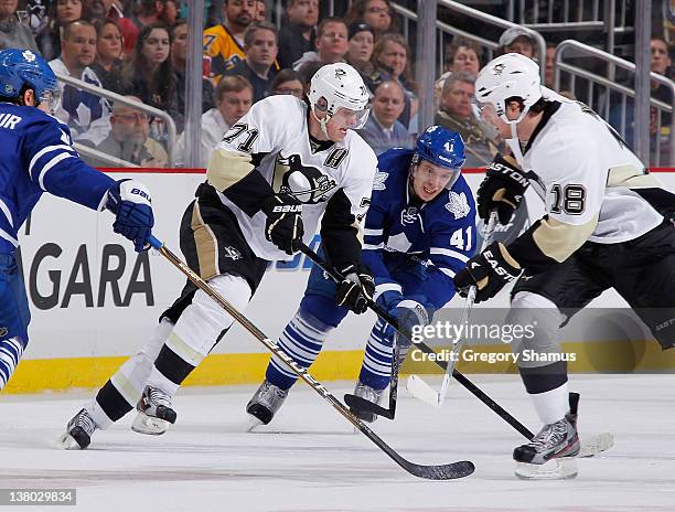 Evgeni Malkin of the Pittsburgh Penguins moves the puck in front of the defense of Nikolai Kulemin of the Toronto Maple Leafs on January 31, 2012 at...