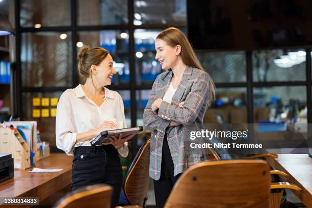 women are driving and shaping the future of your business goals. business development lead is discussion with her team about customers feedback data to improve market share on a tablet in a business office. - feedback imagens e fotografias de stock