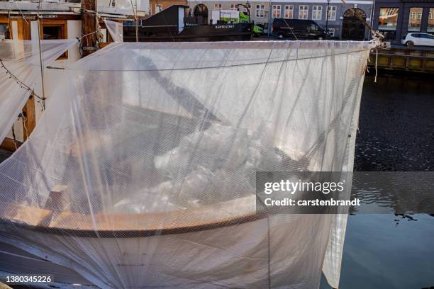 old fishing vessel under a tarpaulin - copenhagen nyhavn stock pictures, royalty-free photos & images