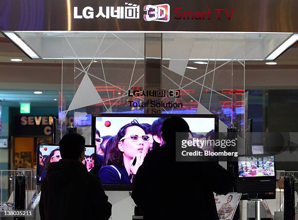 Visitors wearing 3-D glasses look at a LG Electronics Inc. 3-D smart television at the company's showroom in the COEX mall in Seoul, South Korea, on...