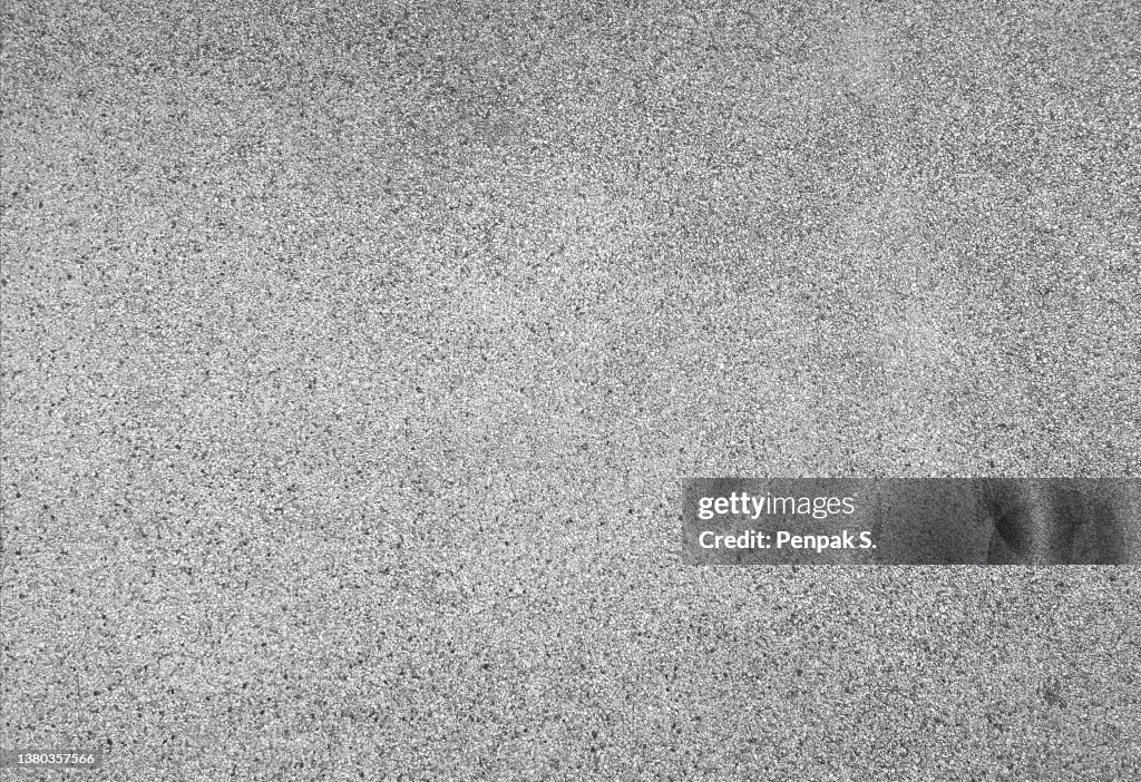 Washed sand floor, black stone grains rough surface texture material background