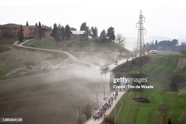 The peloton passing through a dusty gravel strokes sector during the Eroica - 16th Strade Bianche 2022 - Men's Elite a 184km one day race from Siena...