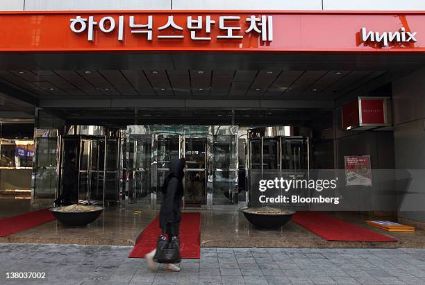 Pedestrian walks past the entrance of the Hynix Semiconductor Inc. Office building in Seoul, South Korea, on Wednesday, Feb. 1, 2012. Hynix...