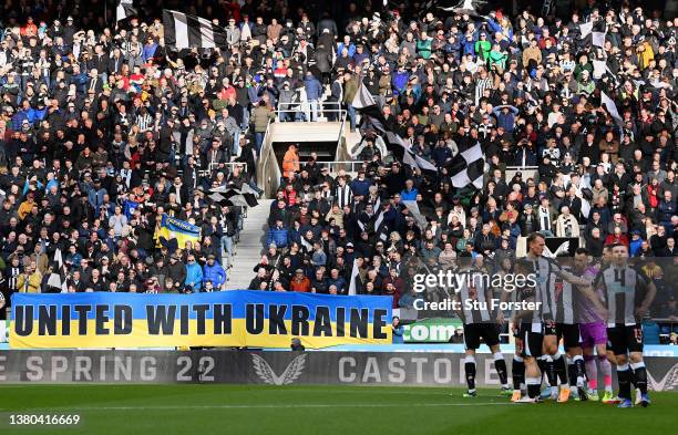 Players, officials and fans take part in a minute of applause to indicate peace and sympathy with Ukraine prior the Premier League match between...
