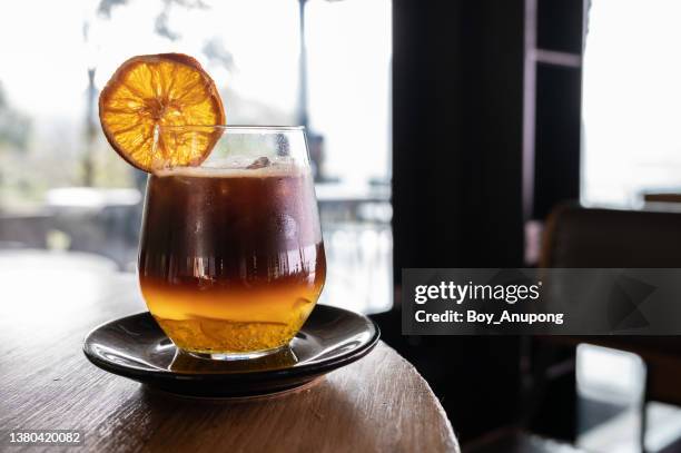 iced orange americano served on table. - americano photos et images de collection