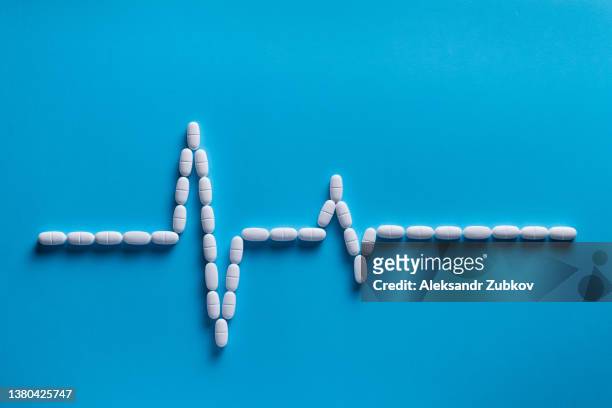 capsules and tablets in the form of a cardiogram. taking vitamins, painkillers, medications. the concept of pharmaceuticals, prevention and treatment of heart diseases, healthcare and medicine. ischemia, stroke and myocardial infarction. - drug concept bildbanksfoton och bilder