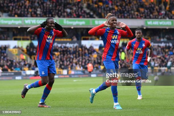 Wilfried Zaha of Crystal Palace celebrates with teammate Jean-Philippe Mateta after scoring their side's second goal from the penalty spot during the...
