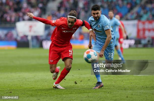 Yussuf Poulsen of RB Leipzig battles for possession with Vincenzo Grifo of SC Freiburg during the Bundesliga match between RB Leipzig and Sport-Club...