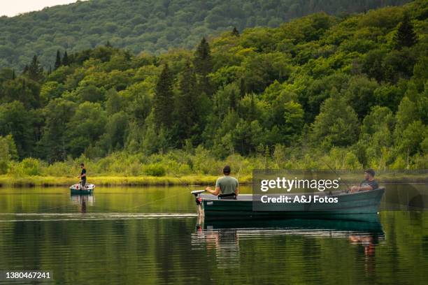 three men fishing on a lake in quebec. - mid adult men stock pictures, royalty-free photos & images