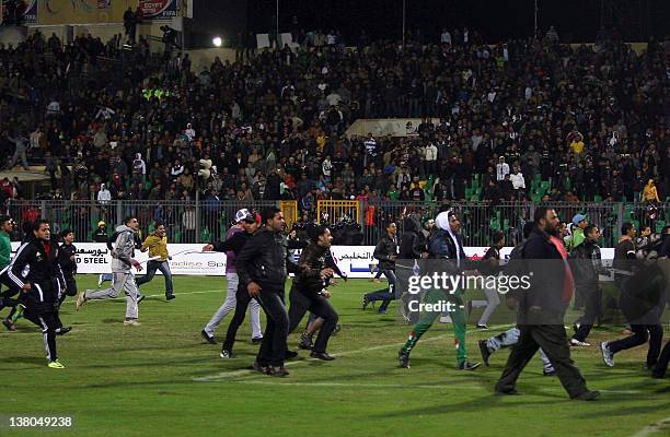 Egyptians football fans rush to the fiels during clashes that erupted after a football match between Egypt's Al-Ahly and Al-Masry teams in Port Said,...