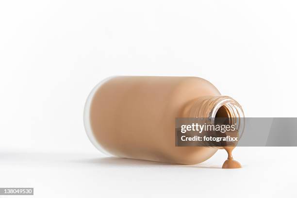 isolated image of bottle of make-up on its side pouring out - cosmetic bottle stockfoto's en -beelden