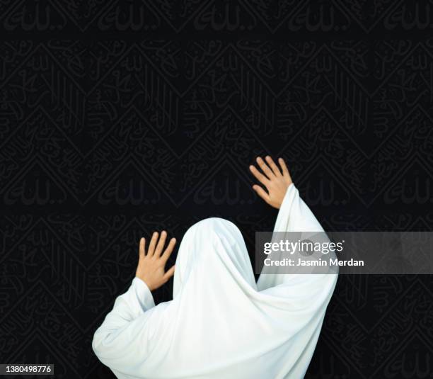 woman touching kaaba while praying at al-haram mosque - pilgrimage stock pictures, royalty-free photos & images