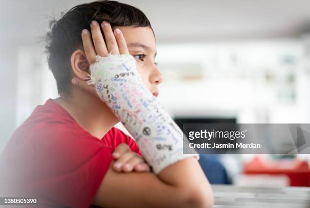 kid with broken arm and friends' signatures on bandage - kind mit armschlinge stock-fotos und bilder