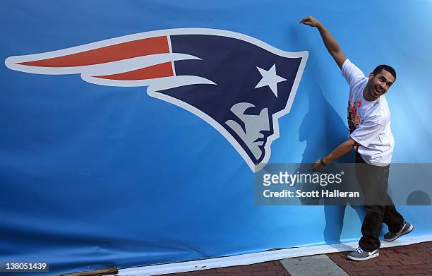 Fan poses for a photo next to a giant New England Patriots logo prior to Super Bowl XLVI between the New York Giants and the New England Patriots on...