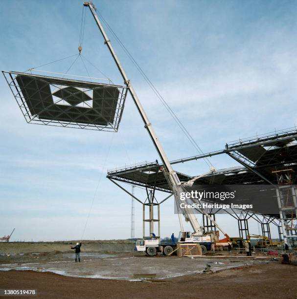 Stansted Airport, Stansted, Stansted Mountfitchet, Uttlesford, Essex, . A crane lifting the final roof dome of the terminal building at Stansted...