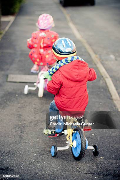 kids riding bicycle on road - roue vélo photos et images de collection