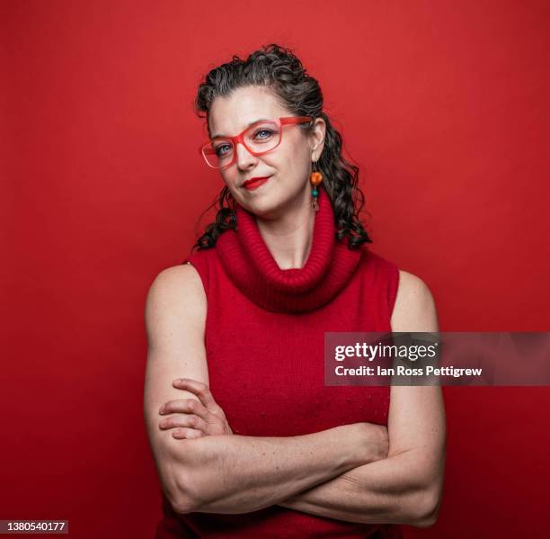 middle-aged woman, arms crossed - portrait femme fond rouge adulte photos et images de collection