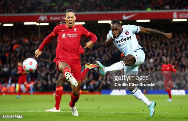 Michail Antonio of West Ham United crosses the ball past Virgil van Dijk of Liverpool during the Premier League match between Liverpool and West Ham...