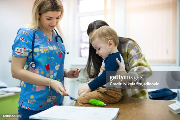 pediatric checking baby patient with reflex hammer - reflex hammer stock pictures, royalty-free photos & images